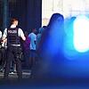 Einsatzwagen der Polizei mit Blaulicht und Polizeibeamte bei einem Einsatz.