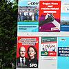 Trotz politischer Unterschiede sind diese acht Wahlplakate an dieser Anschlagswand friedlich vereint: Gesehen in Steißlingen.
