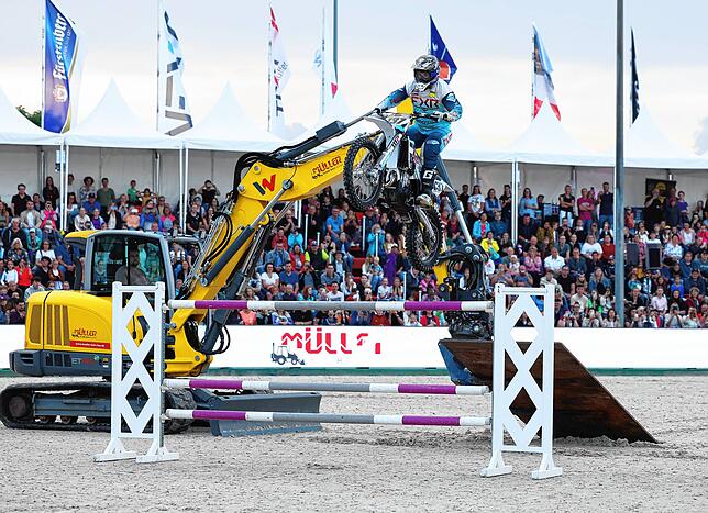 Baggerfahrer Robin Müller baut den Steilsprung auf, sein Bruder springt mit der Motocross-Maschine darüber.
