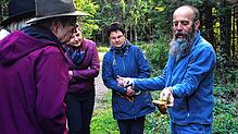 Bei der Exkursion in dem Villinger Stadtwald begutachtet Edgar Riehle gemeinsam mit den Teilnehmern Pilze, die am Wegesrand wachsen.