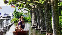 Vier Kinder paddeln im Mai 1999 mit einem Boot über die überflutete Uferpromenade in Unteruhldingen am Bodensee. Bei dem ...