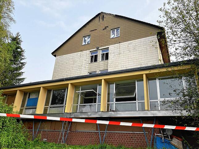 Die Freiflächen um das Gebäude sind abgesperrt, Fenster und Türen stehen offen.