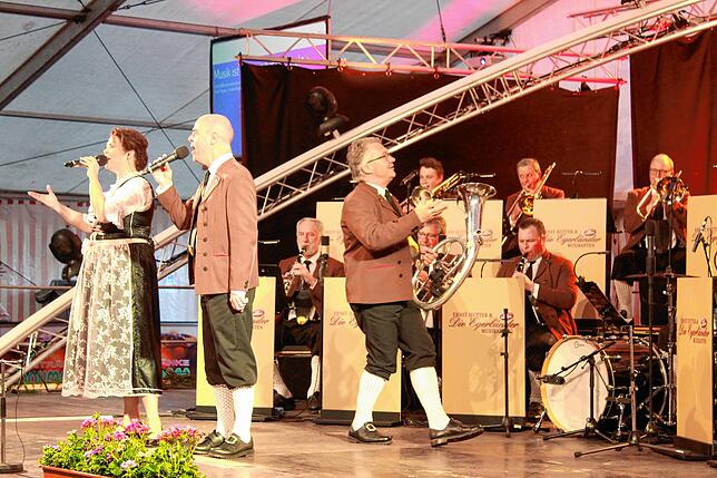 Katharina Praher und Nik Loris singen ins Mikrofon, der Orchesterleiter singt mit – wenn er gerade nicht selbst mitspielt.