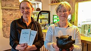 Kirsten Heinzmann (links) und Karin Ettwein zeigen die Gutscheine und das Spendenschwein für Gäste mit kleinem Budget im Café Vielfalt. ...