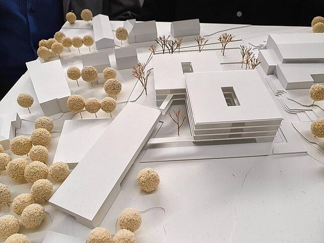 Das Modell zeigt den Neubau als zwei überlappende Quader. Er wird über eine Brücke mit dem alten Musentrakt (links), der stehen bleibt, ...