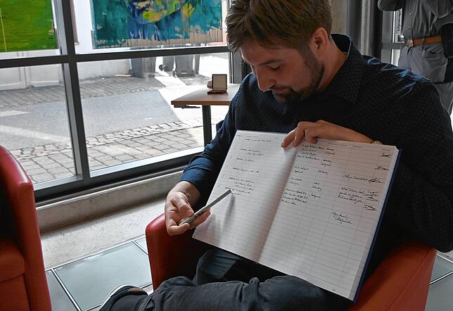 Alle Objekte werden in diesem Buch verzeichnet, das Julian Windmöller zeigt.
