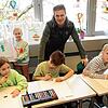 Holger Ahlers mit Kindern der Klasse 2c der Weihermattenschule. Sie sind dabei, Papiertüten zu bemalen, in denen Ahlers zu Weihnachten ...