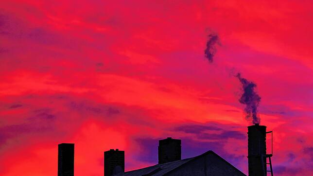 Rauchender Schornstein im Abendhimmel. Die Klimaziele der Bundesregierung machen auch vor den Hausheizungen nicht halt. Auch in den ...