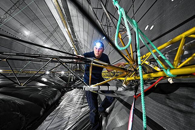 Fluggerätemechaniker Linus Dicomy kontrolliert in der Hülle des Zeppelin NT die Konstruktion und die Verbindungen der Traversen. Über ...