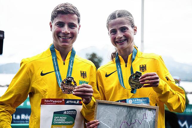 Lukas und Julia Ehrle posieren im National-Dress mit ihren Medaillen bei der Berglauf-EM.