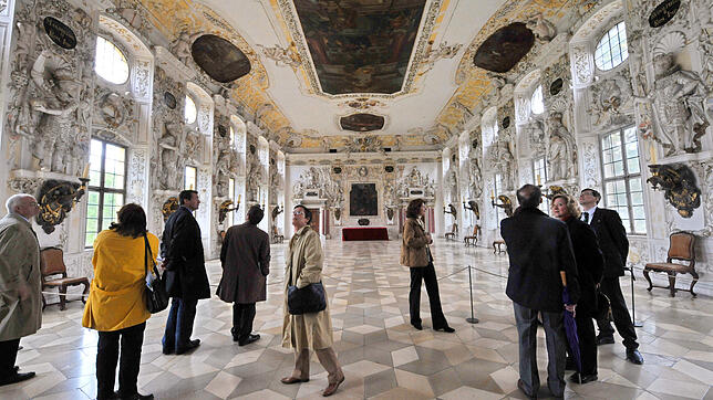 Eine Besuchergruppe steht im Kaisersaal im Schloss in Salem.