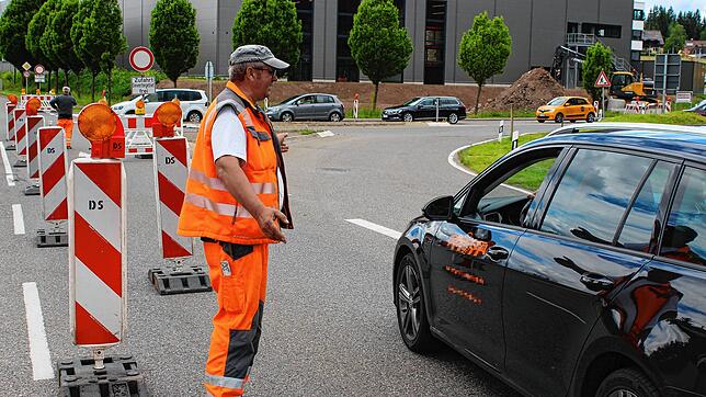 Klaus Bülow, Mitarbeiter der Strabag, erklärt einem Autofahrer kurz nach der Sperrung am Dienstag die neue Verkehrsführung.