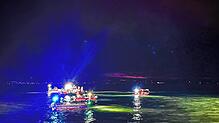 Retter in Booten suchen das Wasser vor dem Ufer Friedrichshafens ab.