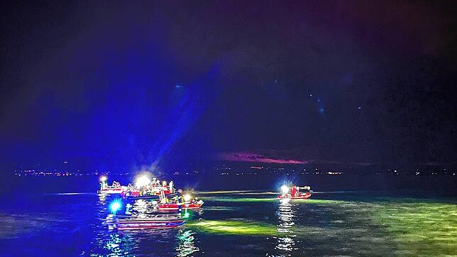 Retter in Booten suchen das Wasser vor dem Ufer Friedrichshafens ab.
