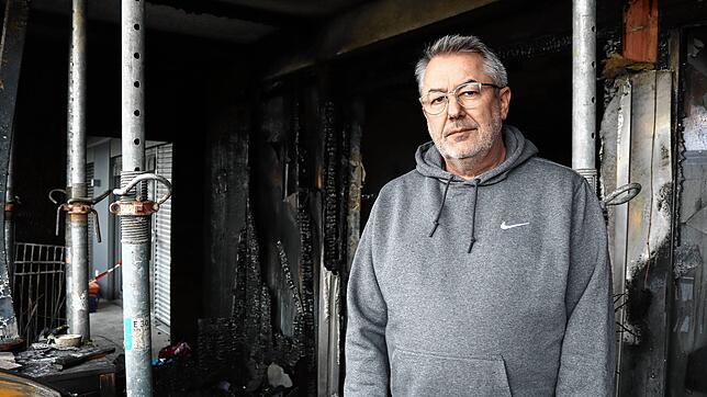 Klaus Meier auf seinem verkohlten Balkon. Die Feuerwehr hat vorsorglich Deckenstützen aufgestellt.
