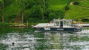 Ein Schwimmer im Rhein begrüsst das frisch getaufte neue Polizeischiff