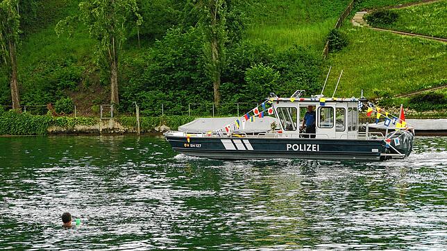 Ein Schwimmer im Rhein begrüsst das frisch getaufte neue Polizeischiff