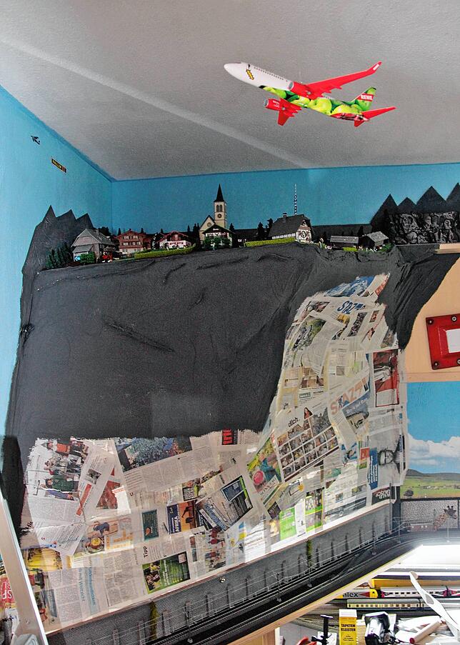 Aktuell entsteht knapp unter der Decke ein neues Bergdorf. Hinten an der Wand passieren die Züge dieses Neubaugebiet.