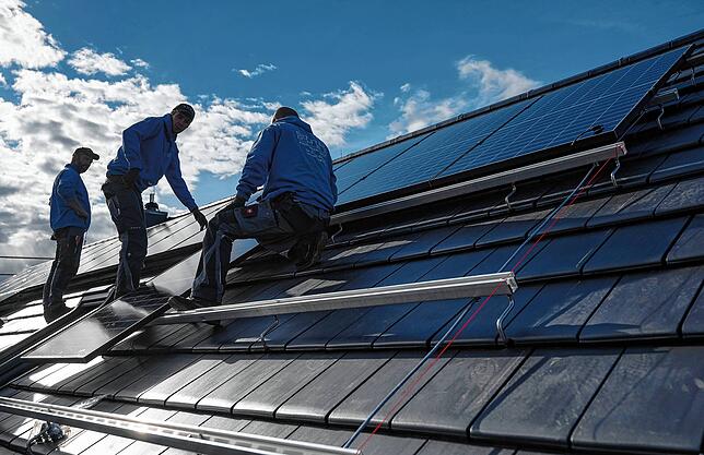Montage von Photovoltaikmodulen auf dem Dach eines Wohnhauses.