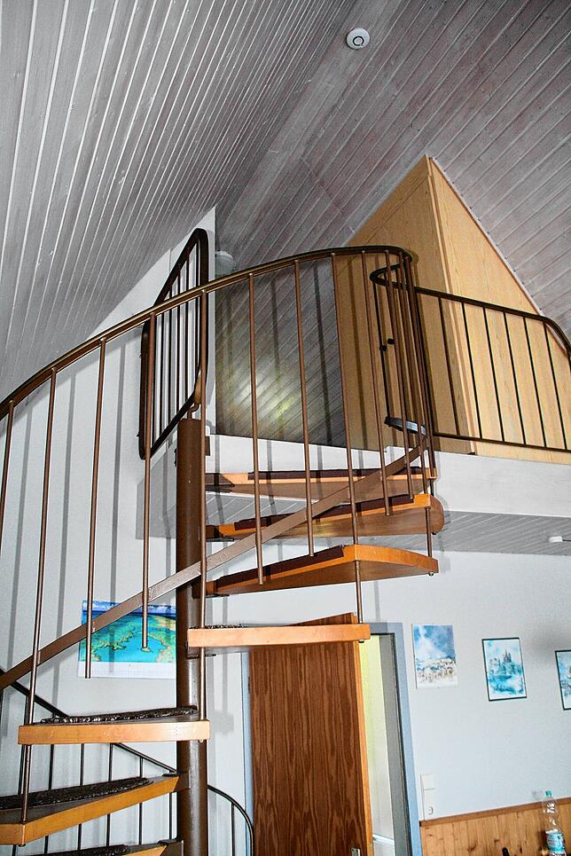 Blick in das Spitzdachhaus von Heinz Gerspach mit der Wendeltreppe. Der Raum ist hell und freundlich.