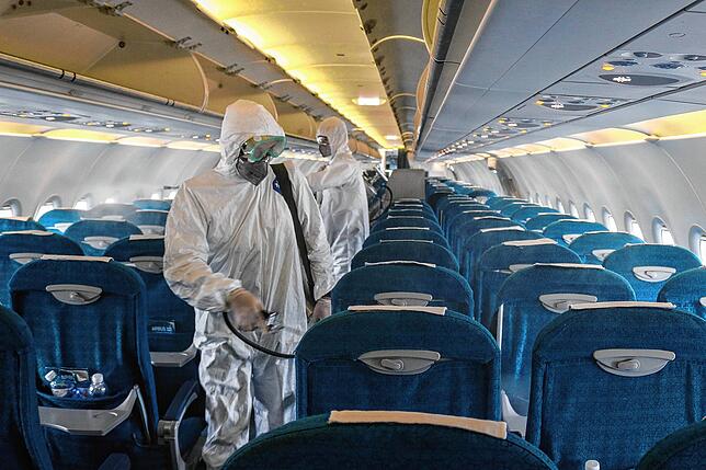 In einem Flugzeug wird im Kampf gegen das Coronavirus Desinfektionsmittel versprüht.
