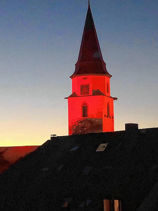 Der Kirchturm der Stadtkirche St. Verena in Hüfingen ist rot angestrahlt.