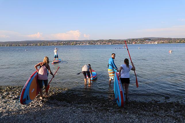 Aufs geht's zur Yoga-Insel: Die Teilnehmer machen sich nach einer Aufwärmphase auf den Weg in den See.