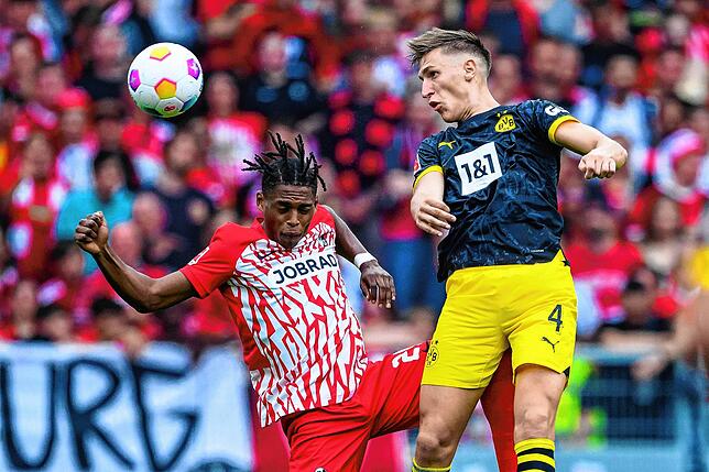 Freiburgs Junior Adamu (l) in Aktion gegen Dortmunds Nico Schlotterbeck (r).