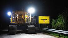 Gegenverkehr ausgeschlossen, weil die Straßenbreite ausgefüllt wird. Der Geräteträger des Großdrehbohrgeräts bewegt sich im Schritttempo ...