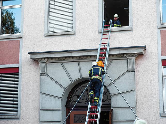 Gesichert an einem Seil und durch einen Feuerwehrmann geht es auf der Schiebeleiter nach unten.