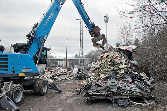 Ein großer Bagger sortiert die zerschnittenen Zugteile auf großen Schrotthaufen. Die Materialien müssen unterschiedlich entsorgt werden. ...