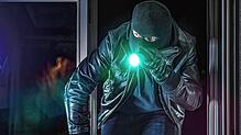Ein Einbrecher leuchtet mit der Taschenlampe. (Symbolbild) In Jestetten-Altenburg steht plötzlich ein Einbrecher vor dem Bett.