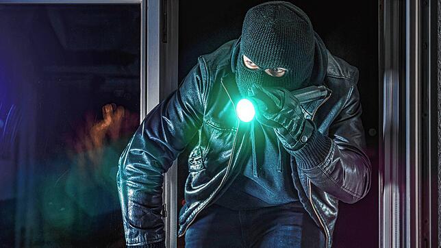 Ein Einbrecher leuchtet mit der Taschenlampe. (Symbolbild) In Jestetten-Altenburg steht plötzlich ein Einbrecher vor dem Bett.
