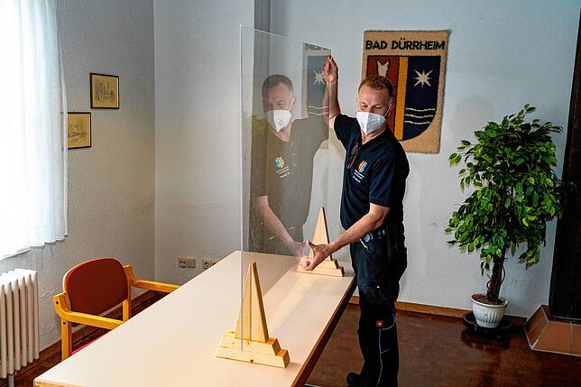 Michael Hauser stellt gerade die Tische und Arbeitsplätze im Anmeldebereich auf.