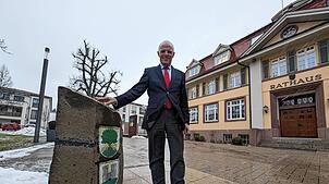 Bürgermeister Fritz Link am Gedenkstein mit den Wappen aller Ortsteile vor dem Rathaus, welcher zum 25. Gemeindejubiläum im Jahr 2000 ...