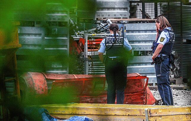 Einsatzkräfte der Polizei stehen auf der Hochbrücken-Baustelle neben der Gondel.