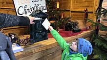 Der fünfjährige Paul wirft seinen Brief an das Christkind in den Briefkasten im Weihnachtspostamt auf dem Singener Hüttenzauber ein. Er ...