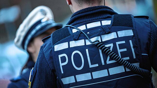 Eine Polizistin (l) und ein Polizist gehen im Rahmen eines Fototermins eine Straße entlang (gestellte Szene). (Symbolbild)