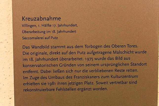 Diese Tafel neben dem Wandbild erläutert den historischen Hintergrund des Gemäldes.