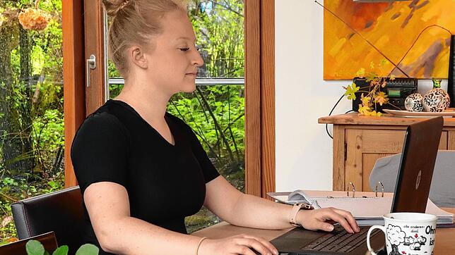 Ellen Schroll im Homeoffice mit dem Erectly Shirt. Das erinnert sie ständig an eine aufrechte Sitzposition.