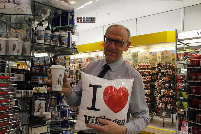 Ulrich Fries verkauft im Drogeriemarkt Müller Souvenirs mit dem "I Love-Motiv".