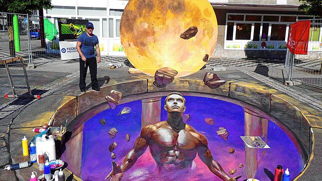 Diese große 3D-Bild zauberte Nikolaj Arndt für das Street-Art-Festival 2019 dem Blumberger Marktplatz. Es zeigt einen Titan, der das ...