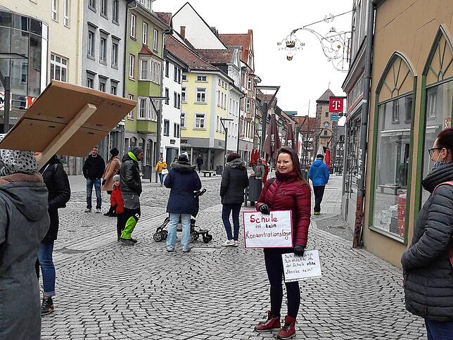Diese Frau trägt ein Plakat mit der Aufschrift „Schule ist kein Konzentrationslager“; damit protestiert sie gegen die ...