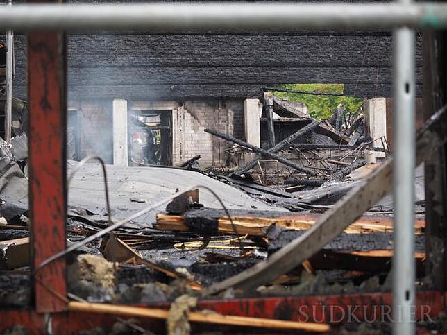 48 Stunden nach Ausbruch des Brandes qualmen die Trümmer immer noch. Auf breiter Front sind die Dachpappen ins Innere gestürzt.