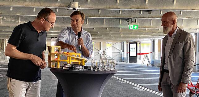 Mit einem Spielzeug-Parkhaus als Geschenk zur Eröffnung sorgte Landrat Zeno Danner (Mitte) für Schmunzler. OB Uli Burchardt (links) und ...