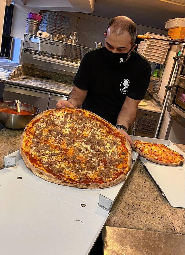 Geschäftsmitinhaber der Pizzeria „Margarethen Schlössle“ Mario Di Sario verpackt Bestellungen.