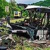 Rettungskräfte stehen an einem ausgebrannten Bus. Dieser Bus kam bei einem Rückstau auf einem Bahnübergang zum Stehen und wurde von ...
