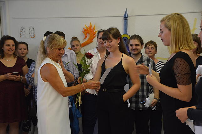 Dank der Absolventen an Christa Bartsch (weißes Kleid), der Leiterin der Kunstschule.