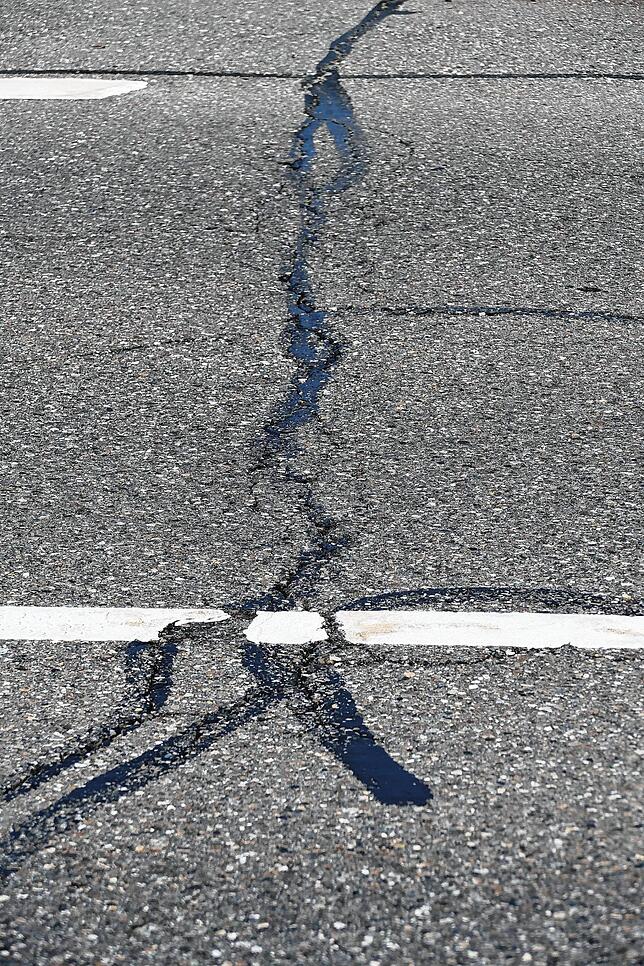 Auf der Bundesstraße klaffen zahlreiche Risse, die Deckschicht ist laut RP ausgemagert.