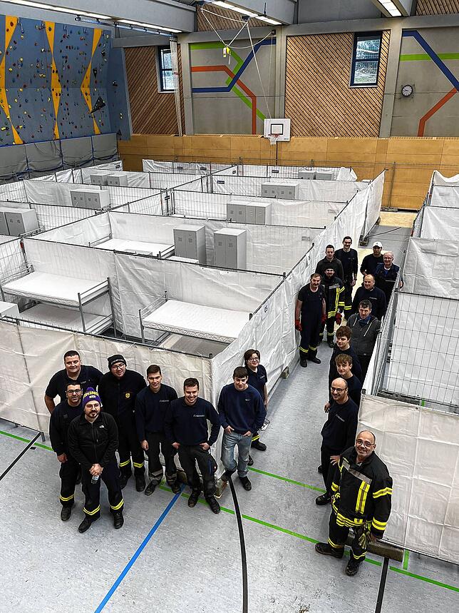 Die Aufbauhelfer in der Kreissporthalle stellen sich 2023 zum Bild auf. Das Gebäude wurde zur Flüchtlingsunterkunft umgestaltet.